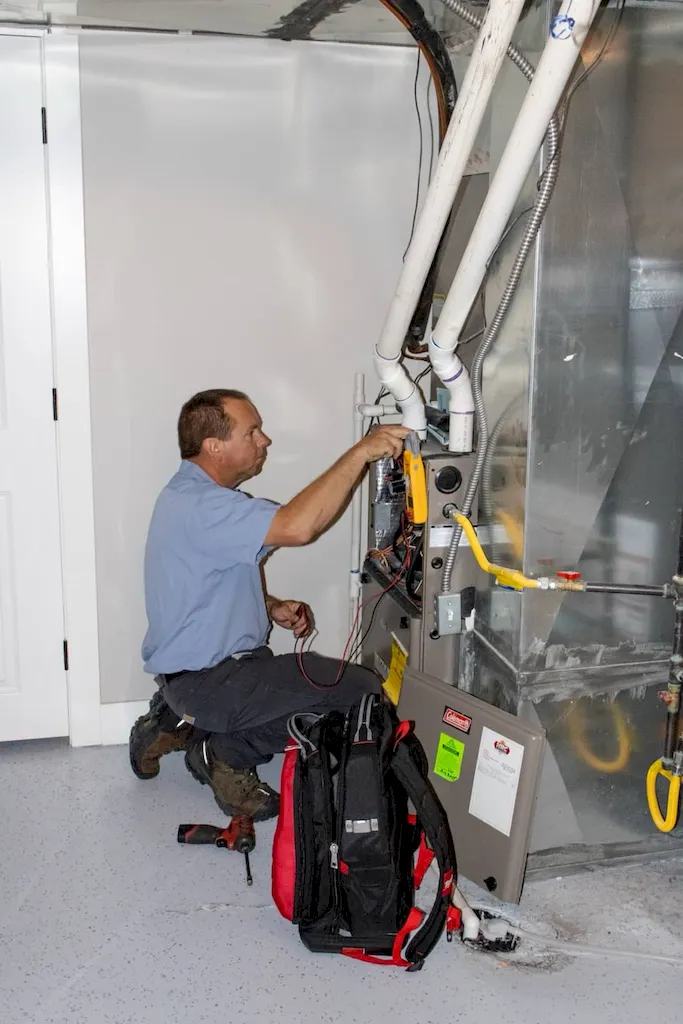 HRC technician servicing an HVAC unit in a basement
